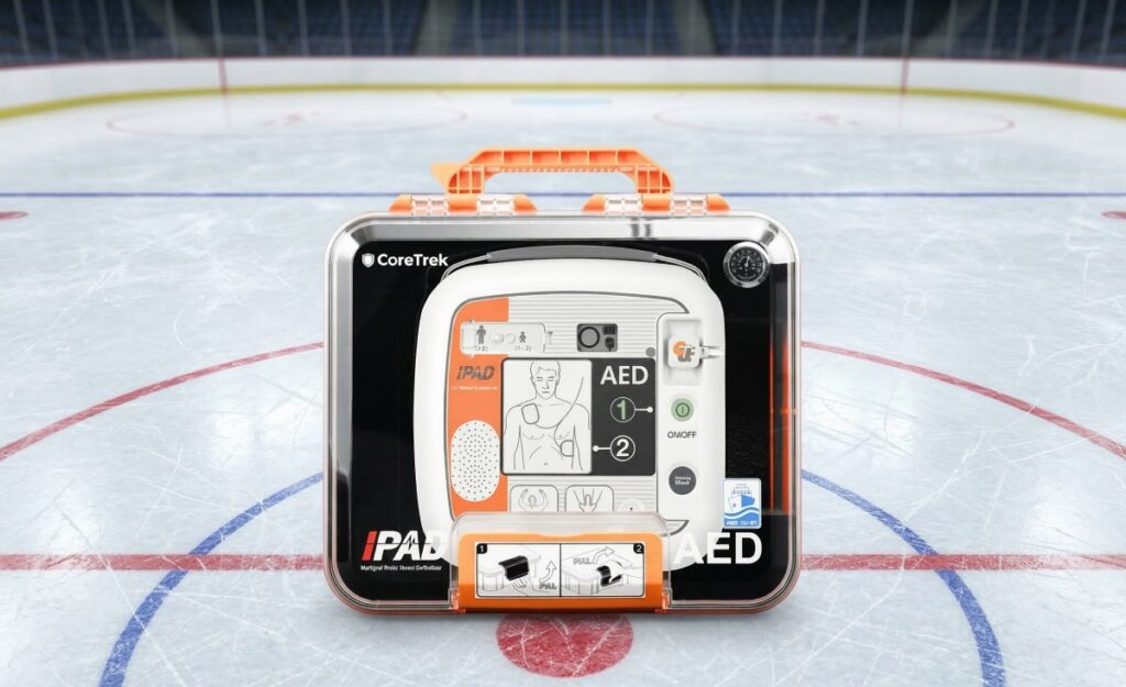 Automatisierter Externer Defibrillator (AED) in einem Schutzkoffer auf dem Mittelpunkt eines Eishockeyfeldes.