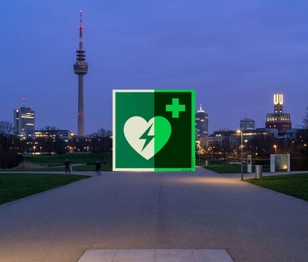 Großes grünes AED-Defibrillator-Symbol über der Skyline von Dortmund im Westfalenpark bei Dämmerung mit Florianturm und Dortmunder U.