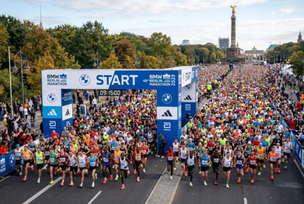 Tausende Läufer beim Start des 49. BMW Berlin-Marathon 2023 unter dem blauen Startbogen mit Blick auf die Siegessäule im Hintergrund.