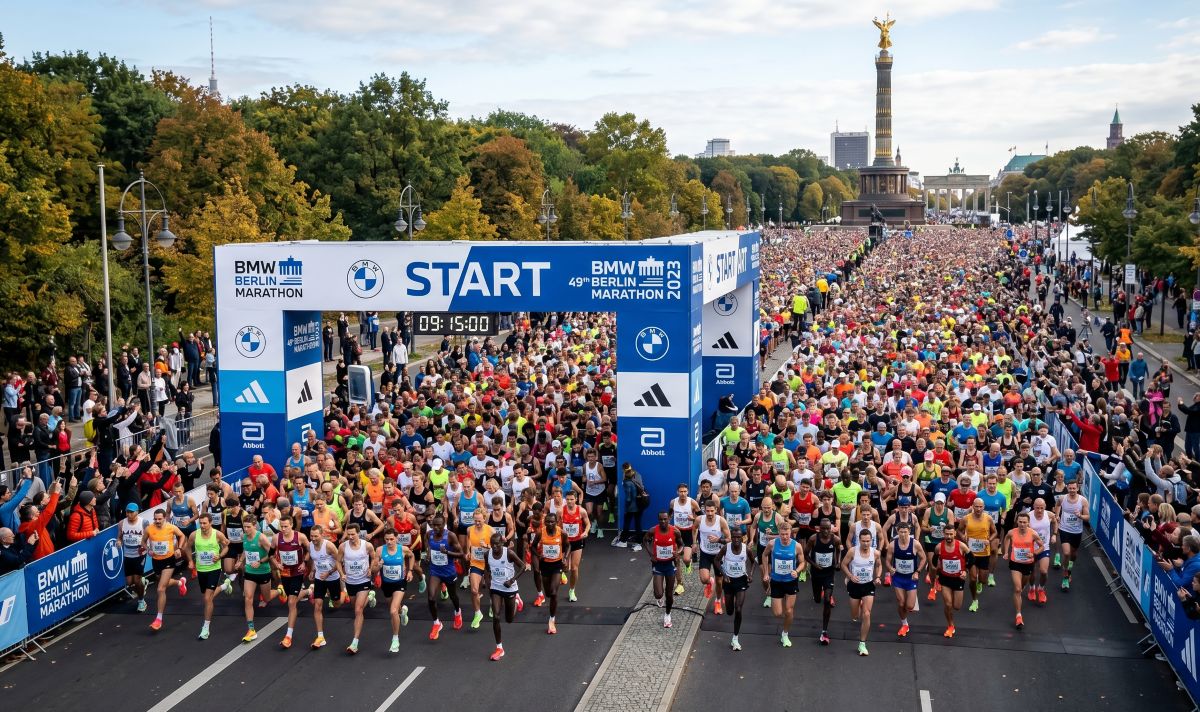 Tausende Läufer beim Start des 49. BMW Berlin-Marathon 2023 unter dem blauen Startbogen mit Blick auf die Siegessäule im Hintergrund.